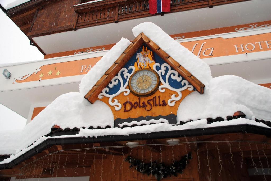 维哥迪法萨多尔希拉公园酒店的雪覆盖的建筑物一侧的时钟