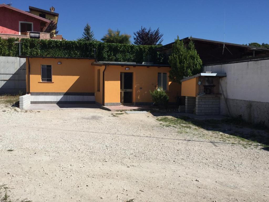 拉奎拉casetta dell'Alpino的屋顶上常有常春藤的黄色房子