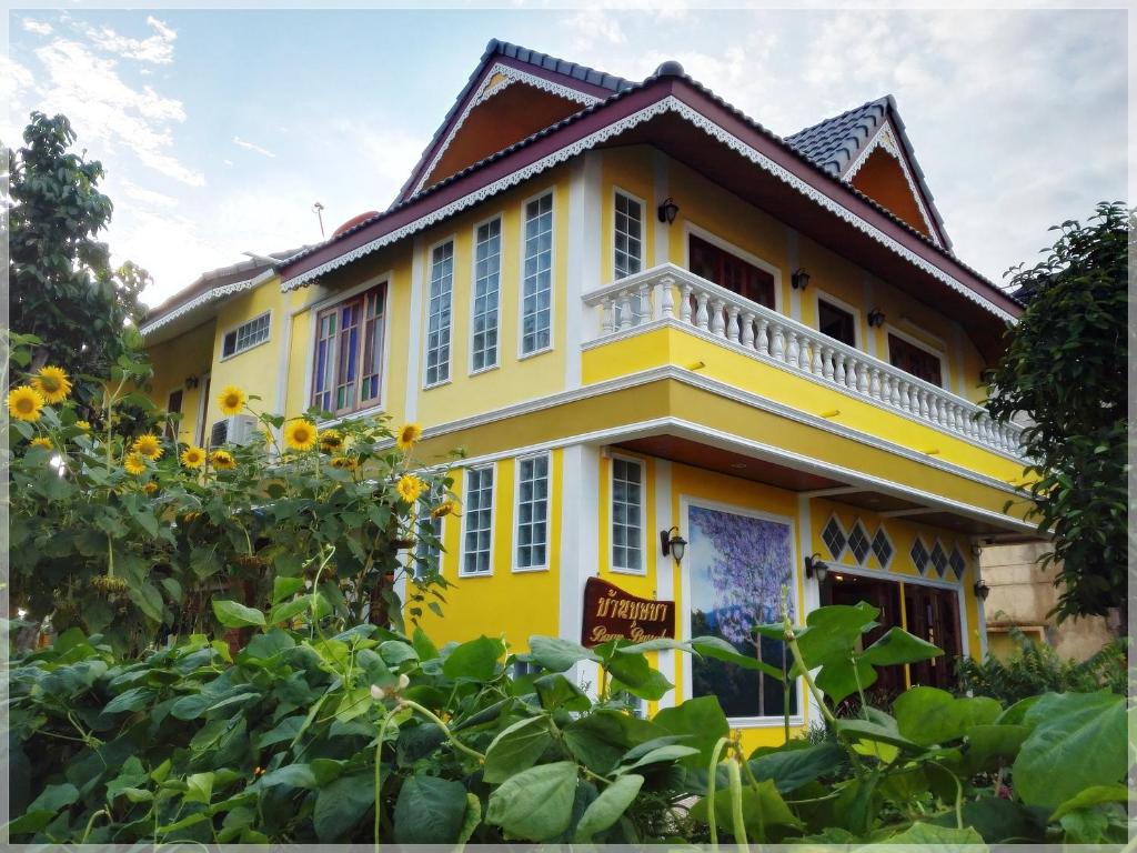 董里班布萨巴酒店的一座黄色房子,前面有向日葵
