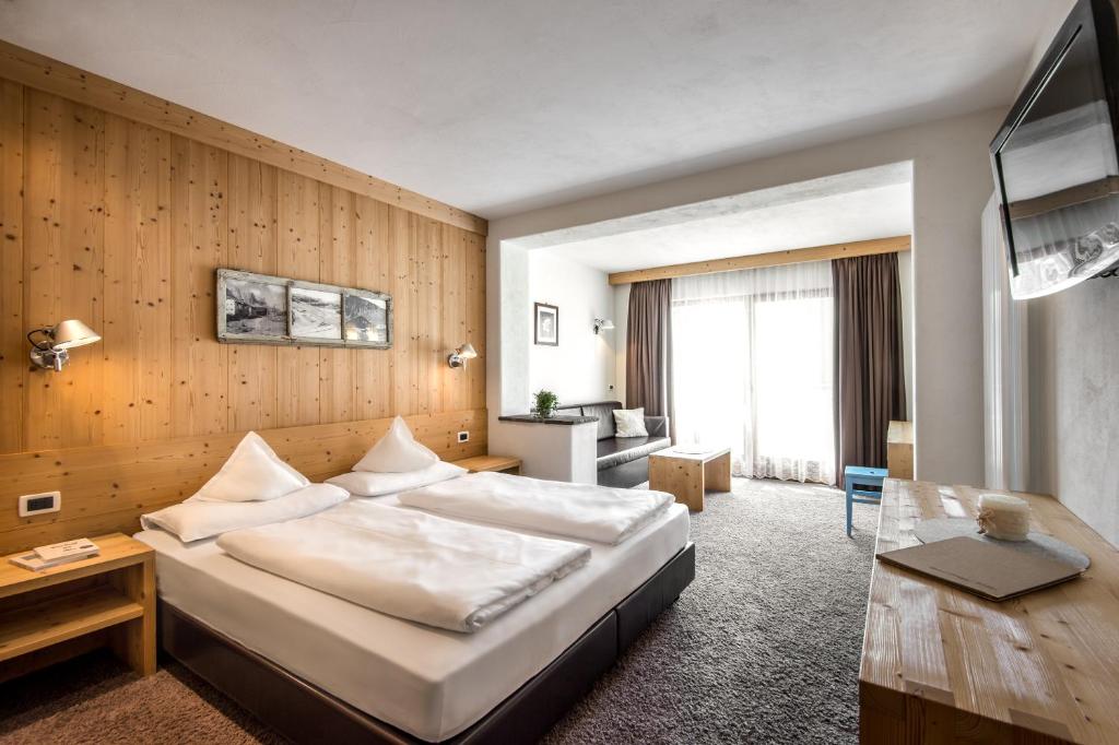 科尔福索西亚萨大酒店的酒店客房设有一张大床和一张书桌。