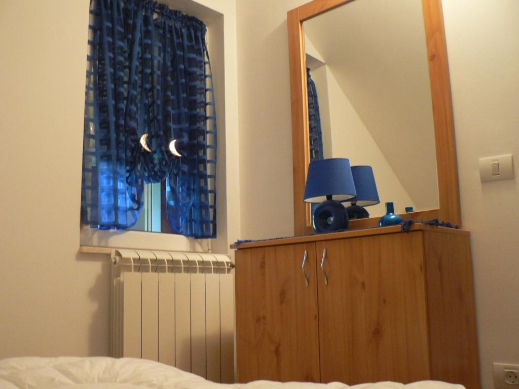 兹拉蒂博尔Apartman Sneznik的一间卧室配有镜子和一个带灯的梳妆台