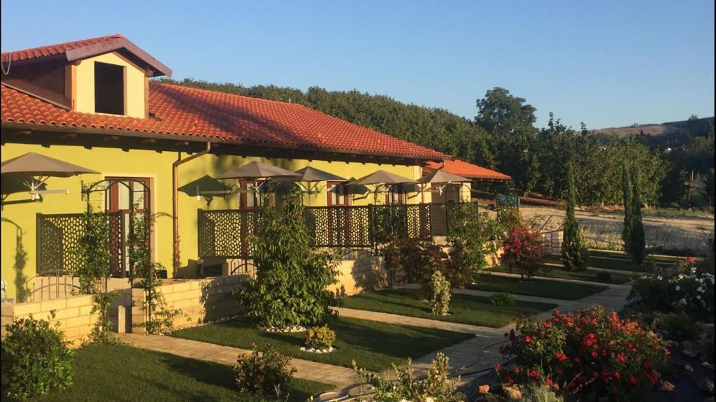 阿尔巴艾格日特日斯莫麦玛酒店的花园中带遮阳伞的黄色房子