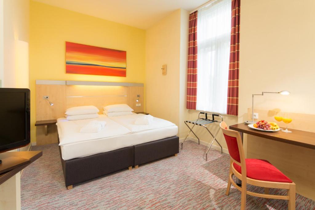 布拉格埃克城市公园酒店的酒店客房配有一张床和一张带电脑的书桌