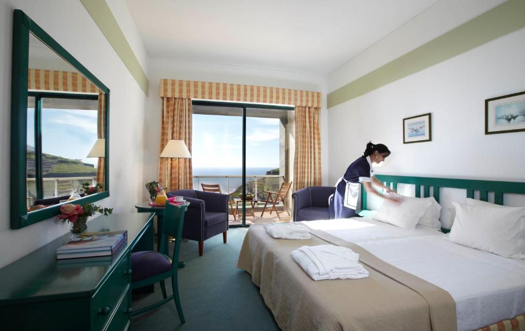 丰沙尔校园酒店的一位妇女站在酒店带床的房间
