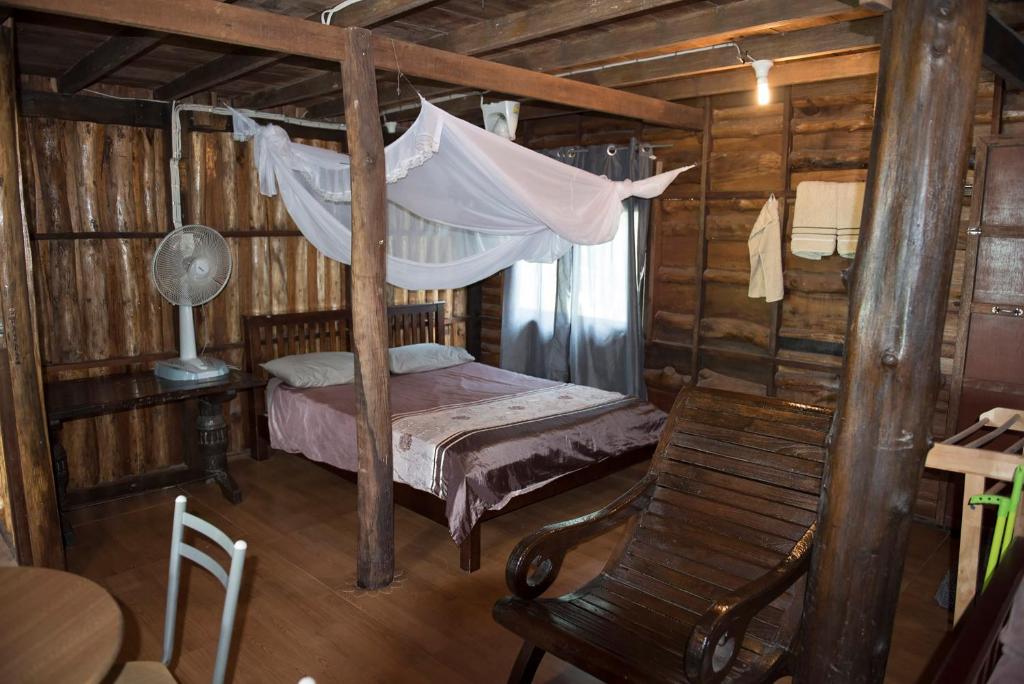 皮皮岛向日葵船屋的一间卧室配有一张带吊床和椅子的床