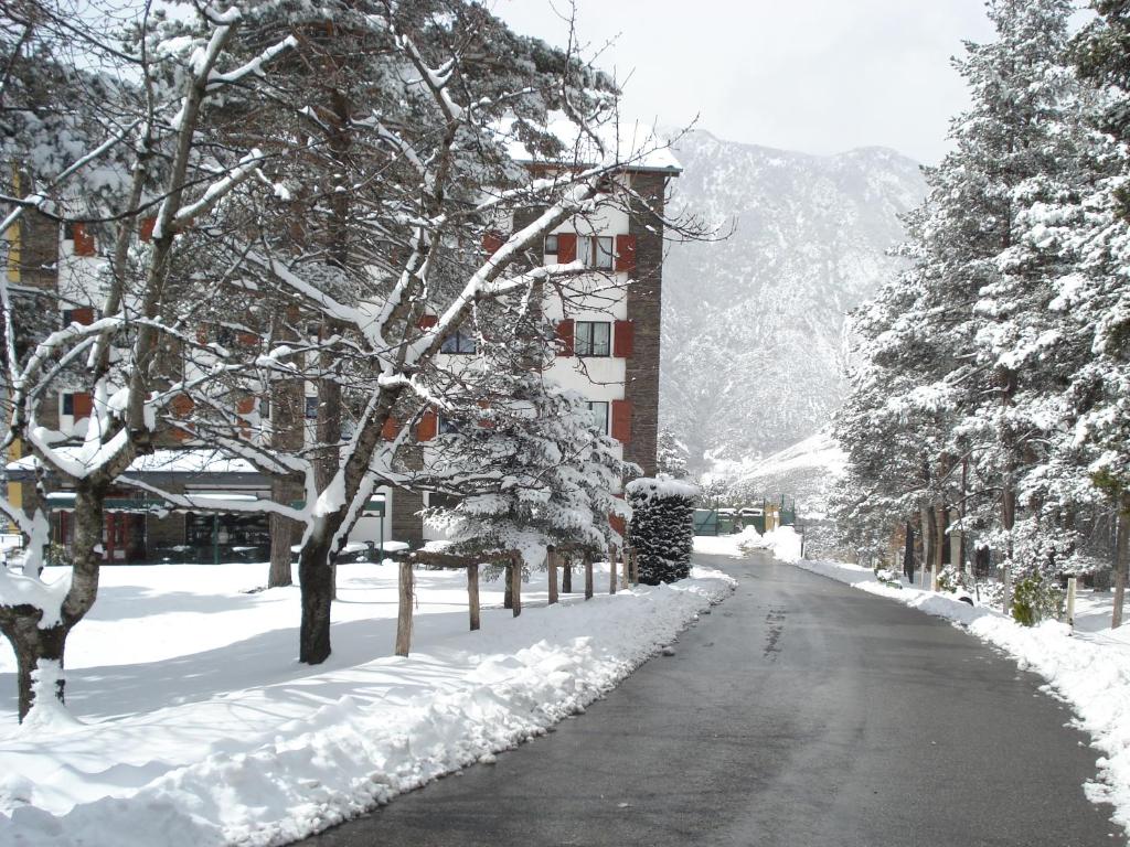 圣胡利娅-德洛里亚科马贝拉酒店的一条有树木和建筑物的雪覆盖的街道