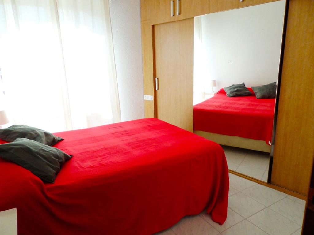 马拉加Dream Apto Old Town的一间卧室配有两张红色的床和镜子