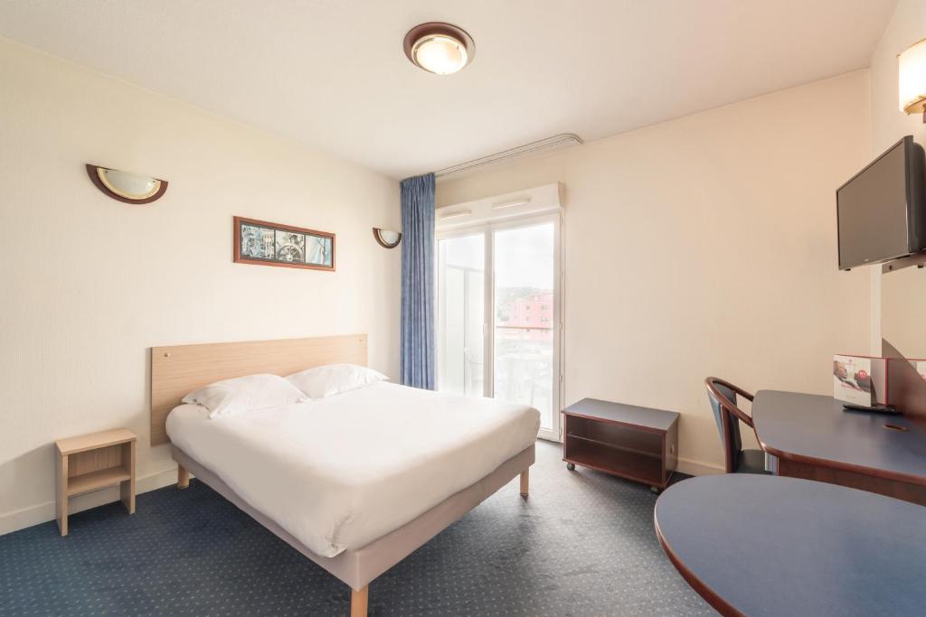 昂蒂布Appart'City Classic Antibes的酒店客房设有床、桌子和窗户。