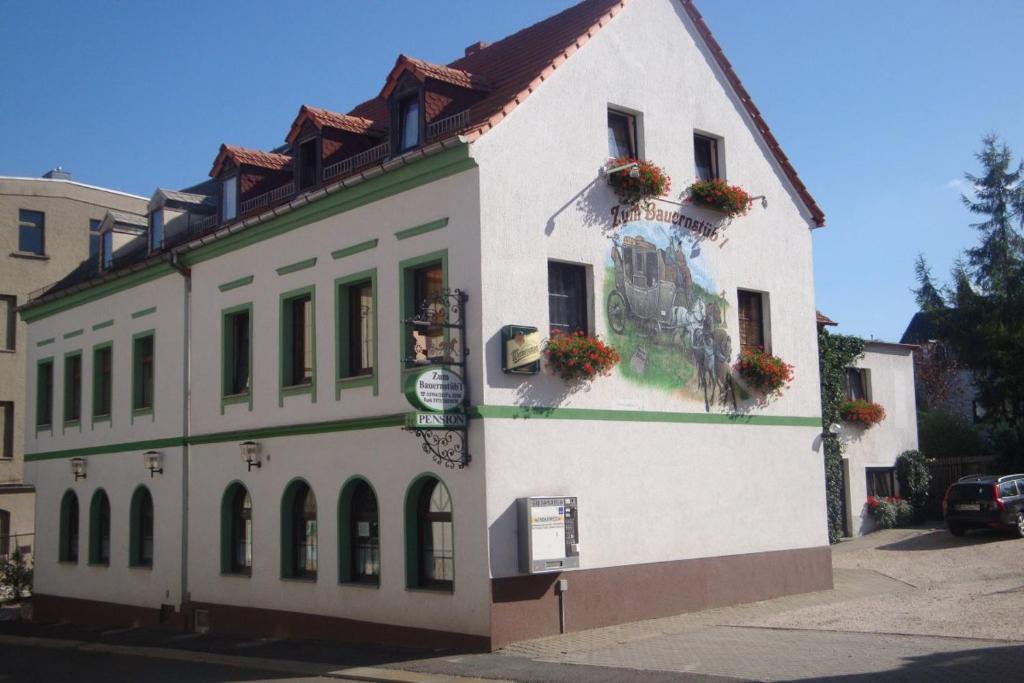 梅拉内Pension Zum Bauernstübl的白色的建筑,花朵在建筑的一侧