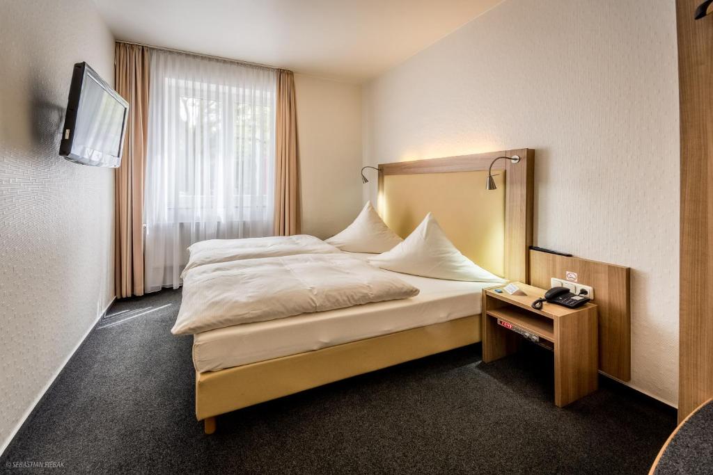 亚琛劳兹贝格酒店的酒店客房,设有床铺和床头柜