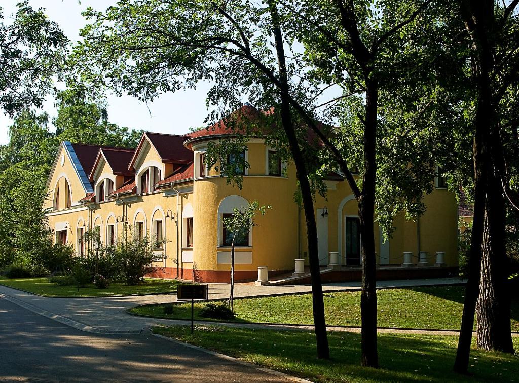 洛约什米热格雷比马厩乡村酒店的前面有一条路的大黄房子