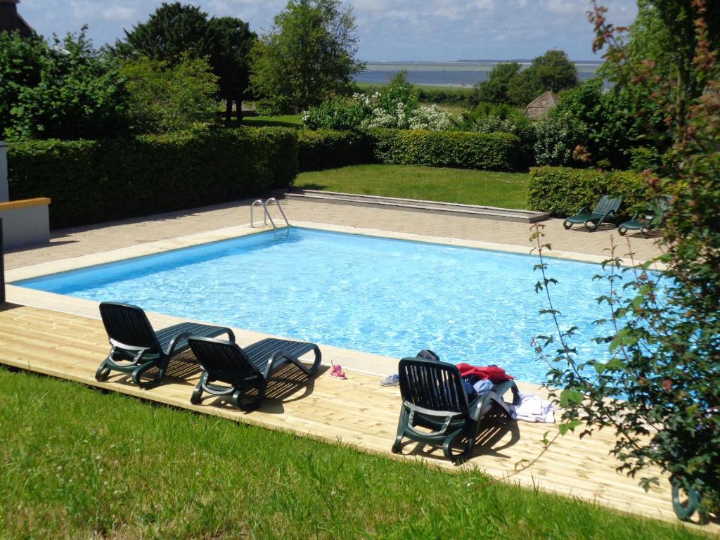 索姆河畔的圣瓦列里卡普霍尔努旅馆的一个带两把椅子和一对夫妇的游泳池