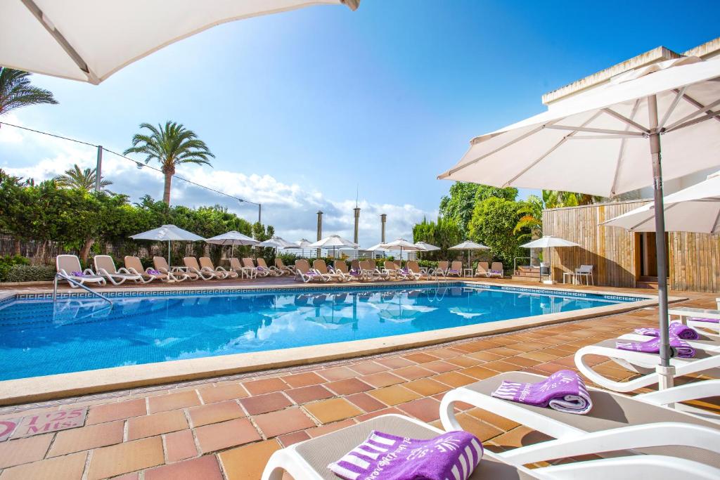 马略卡岛帕尔马Be Live Experience Costa Palma的一个带躺椅和遮阳伞的游泳池