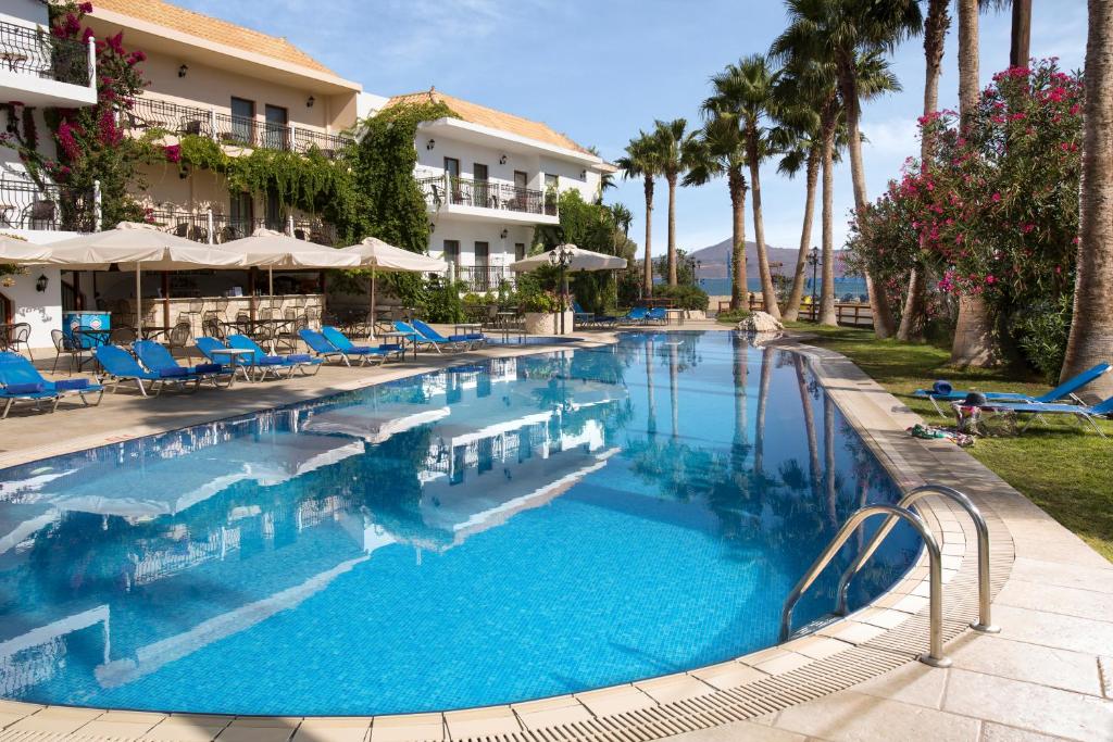 阿尔米里达阿尔米利达度假酒店的一个带蓝色椅子和棕榈树的大型游泳池