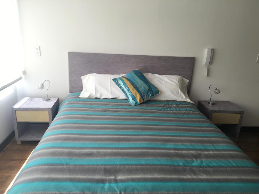 基多Apartamento Finlandia Park Suite的一间卧室配有一张带2个床头柜的大床