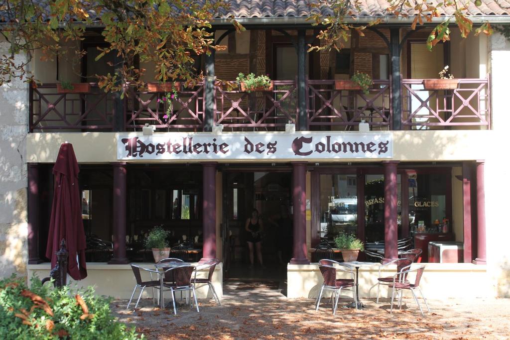 La ForceHostellerie des Colonnes的大楼前设有桌椅的餐厅
