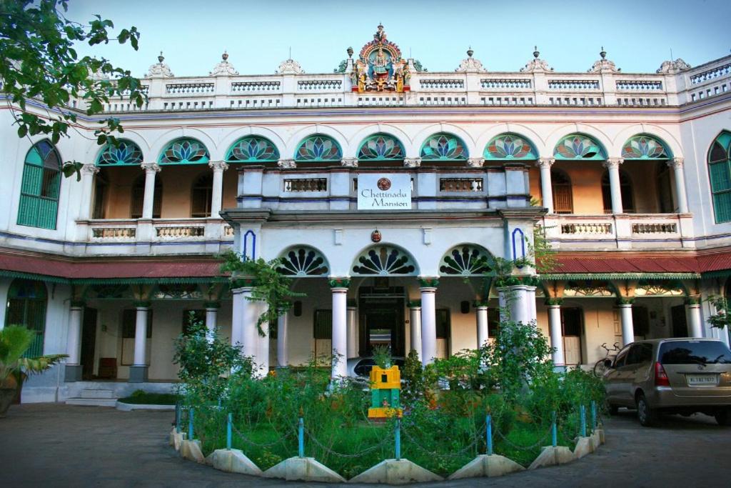 KānādukāttānChettinadu Mansion – An Authentic Heritage Palace的一座大型建筑,前面有停车位