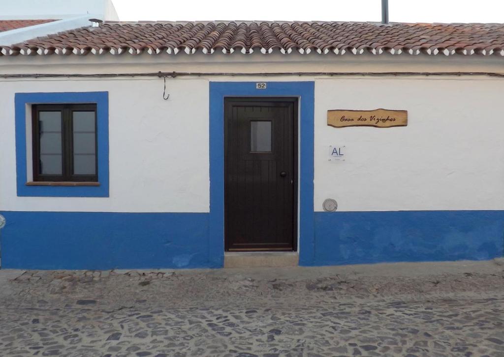 São Pedro do CorvalCasa dos Vizinhos - Casas de Taipa的蓝白色的建筑,有门和标志