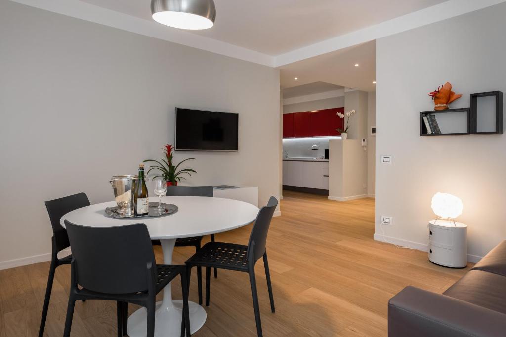维罗纳Flats4rent的用餐室以及带白色桌椅的起居室。