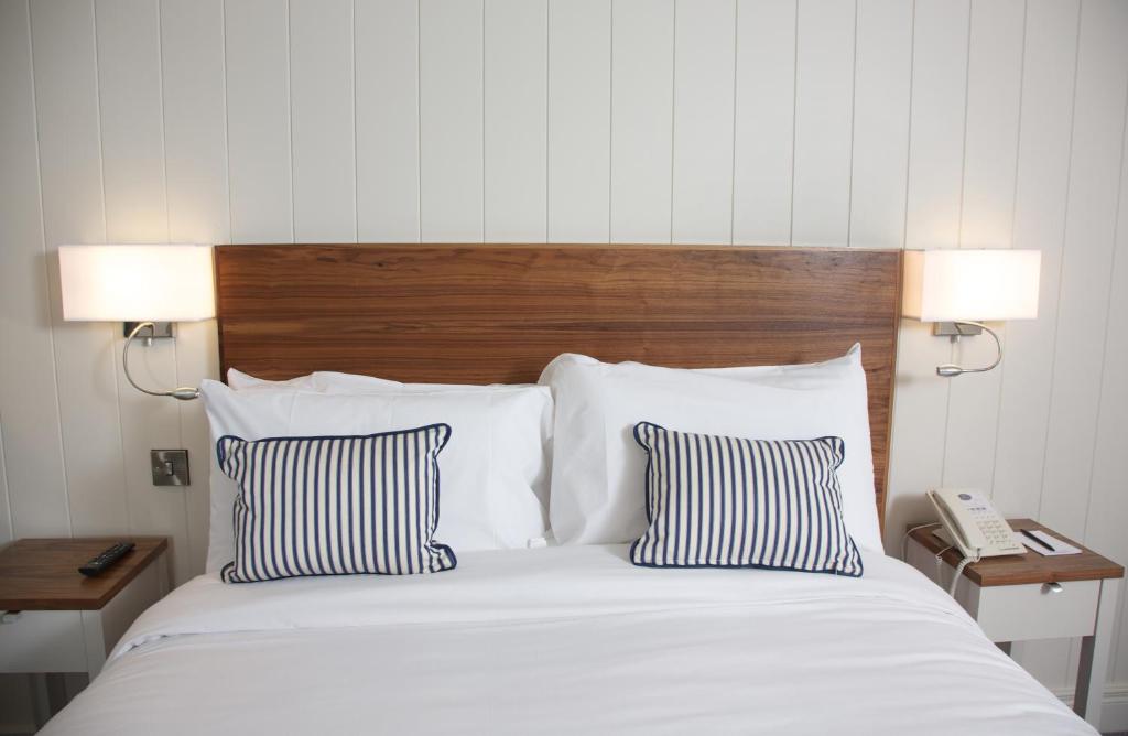 邓格洛Waterfront Hotel Dungloe的一间卧室配有一张带两个枕头的床和一部电话