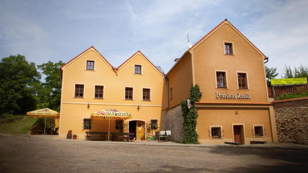 米库洛夫扎提西旅馆的一座黄色的大建筑,前面有一间餐厅