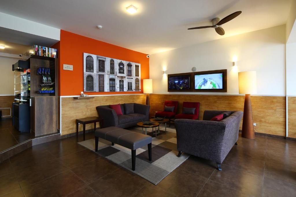 利马圣安东尼奥米拉弗洛雷斯标准卡萨安迪娜酒店的一间设有椅子和墙上电视的等候室