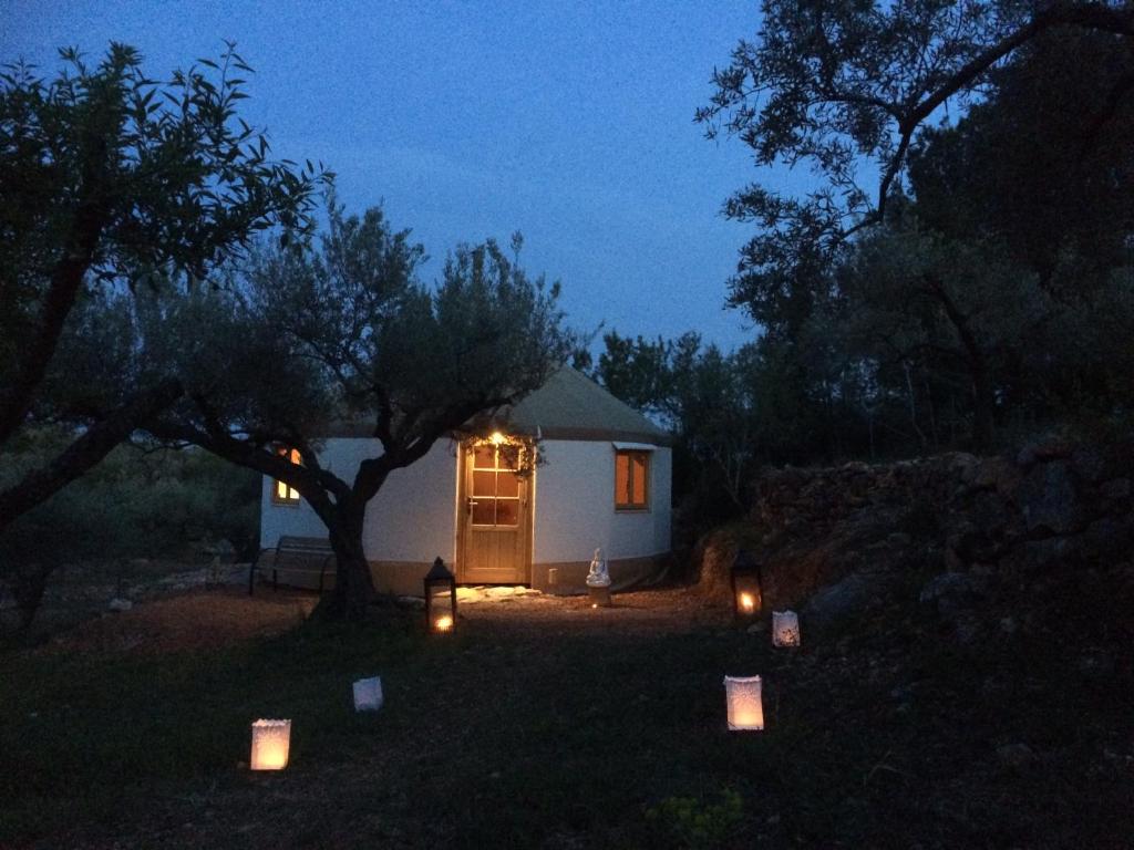 卡马尔莱斯Yurta Mongola Delta del Ebro的一间白色的小小屋,晚上在小屋前放蜡烛