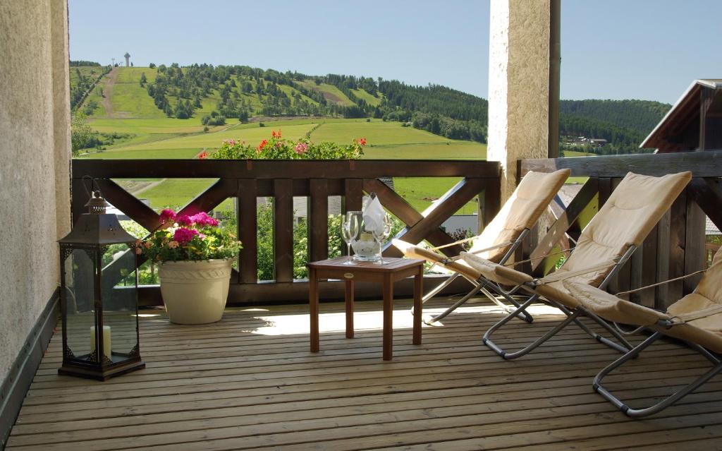 维林根Hotel Magdalenenhof inklusive MeineCardPlus的一个带两把椅子和一张桌子及鲜花的甲板