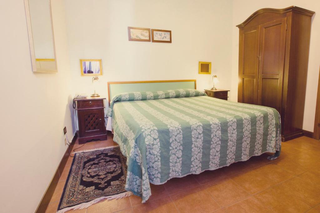维泰博Hotel Centrale的一间卧室配有一张带绿色和白色床单的床。