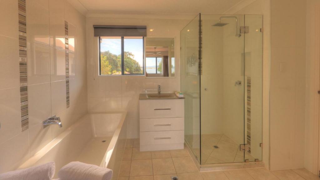 帝坎湾海豚沃特酒店的带淋浴、浴缸和盥洗盆的浴室