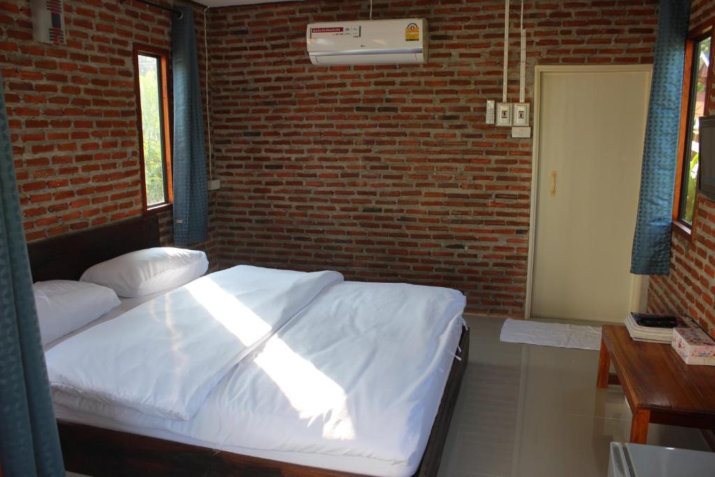 清刊班苏安拉月亮旅馆的卧室配有白色的砖墙床