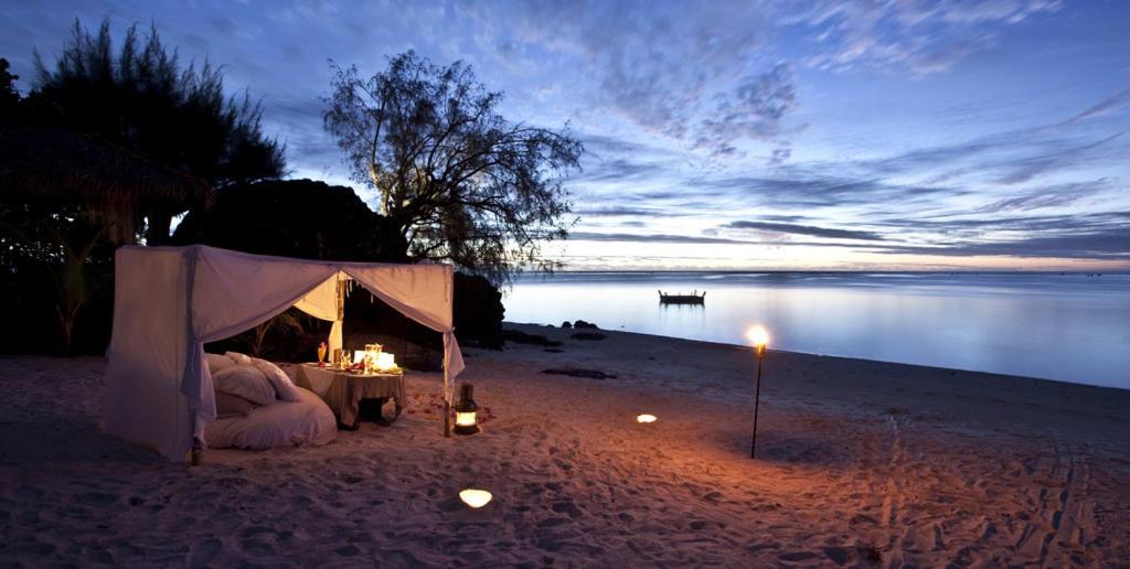 尼基季Maras Marinas Home的海滩上的帐篷,配有桌子和蜡烛