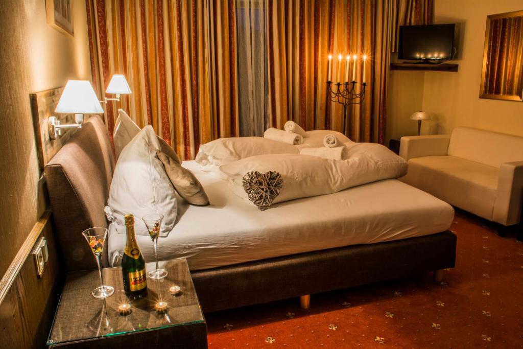 拉姆绍达赫斯坦Pension Savisalo的酒店客房,配有床和桌子,配以酒杯