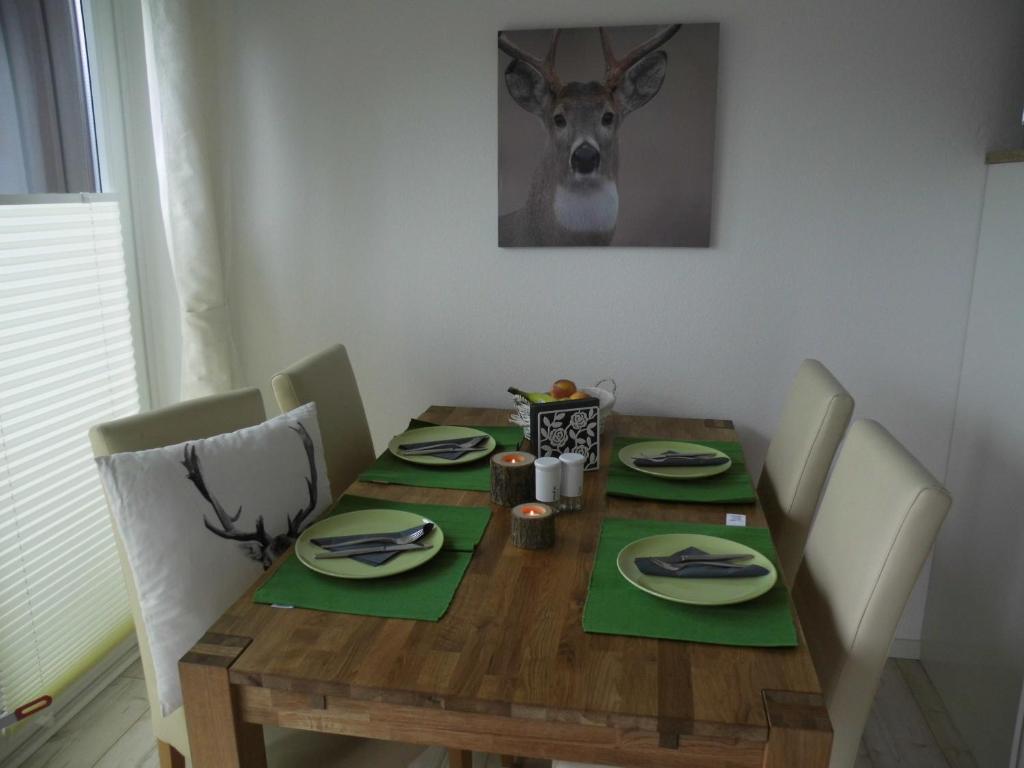 布劳恩拉格Fewo Schröder - Harzflair的一张带绿色餐巾和鹿头的木桌
