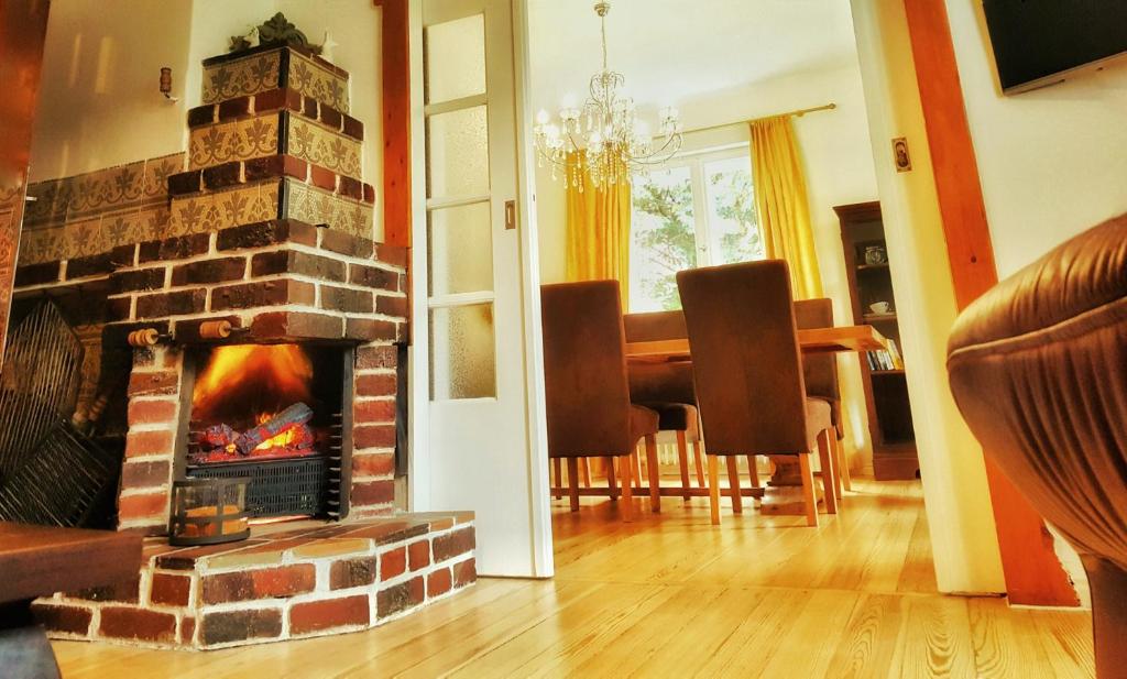 施塔恩斯多夫无忧宫度假屋的客厅设有壁炉和餐桌。