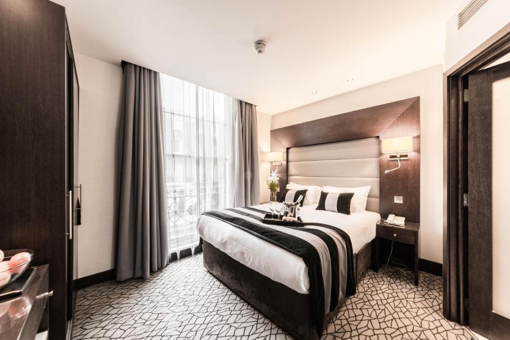 伦敦贝克街公园大道酒店的一间设有大床和窗户的酒店客房