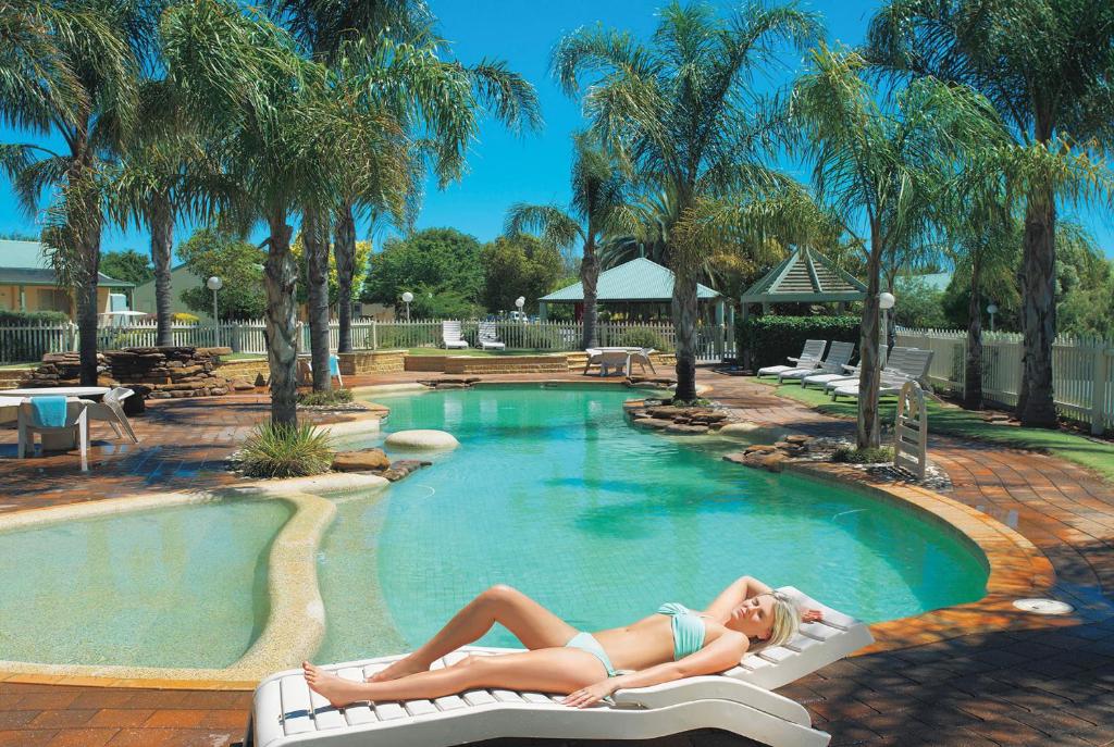 天鹅山穆雷丘陵度假酒店的躺在游泳池椅子上的女人