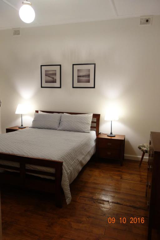 开普敦杰维斯Morella Farmstay的一间卧室配有一张床和两张台灯。