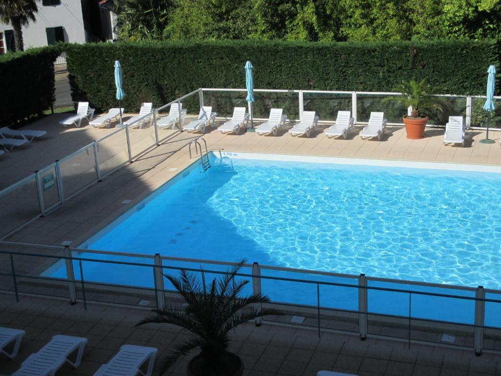 西布勒Appartement Golf et Nivelle avec piscine et parking的一个带躺椅的大型蓝色游泳池