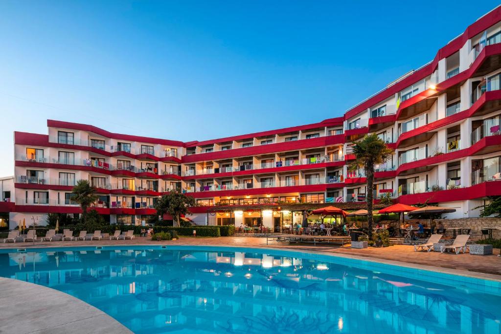 阿尔布费拉Hotel da Aldeia - Adults Only的大楼前设有游泳池的酒店