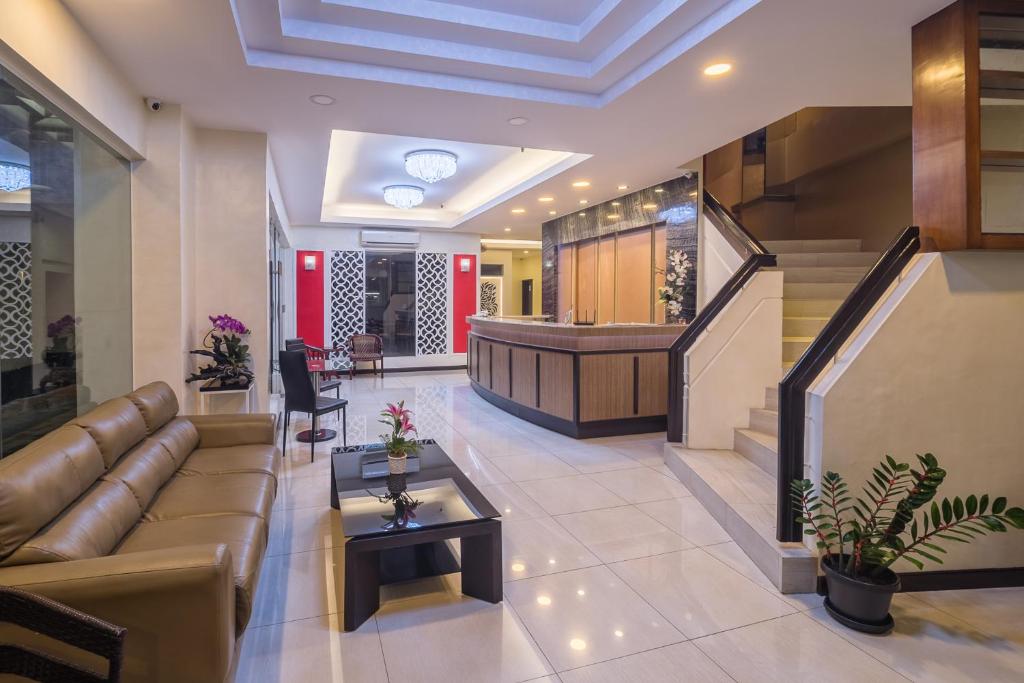 独鲁万亚洲之星酒店 的大堂配有沙发、桌子和楼梯