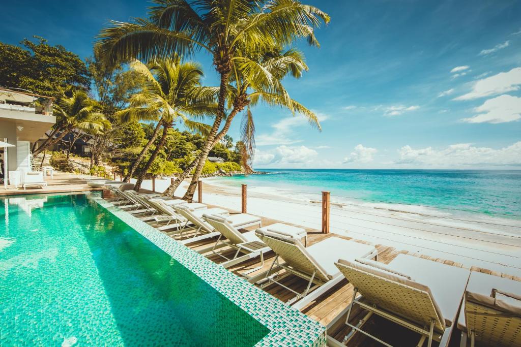 Glacis卡瑞娜海滩酒店的海滩旁的游泳池,带椅子和大海