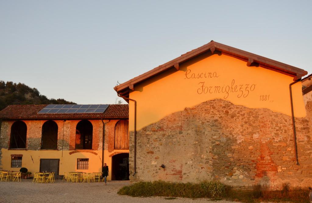 Arquata Scrivia卡希纳佛明格佐农家乐的一座橙色的建筑,旁边标有标志