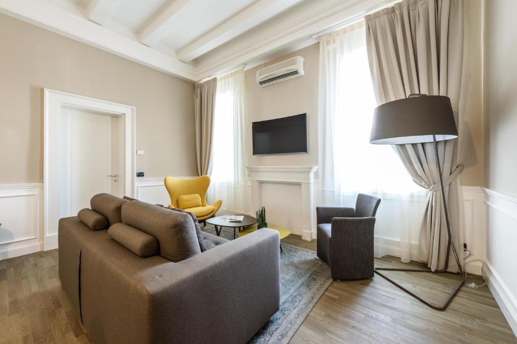 帕多瓦Palazzo Bovio - Boutique Apartments的客厅配有沙发和两把椅子
