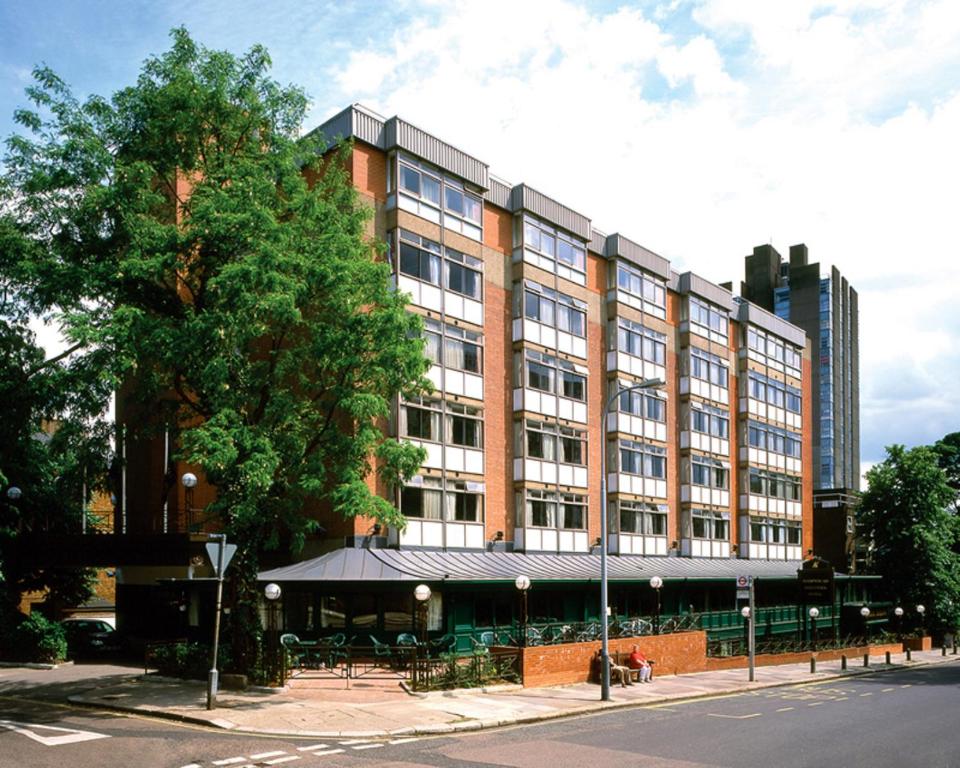 伦敦大不列颠汉普斯蒂德酒店的前面有一棵树的大型砖砌建筑