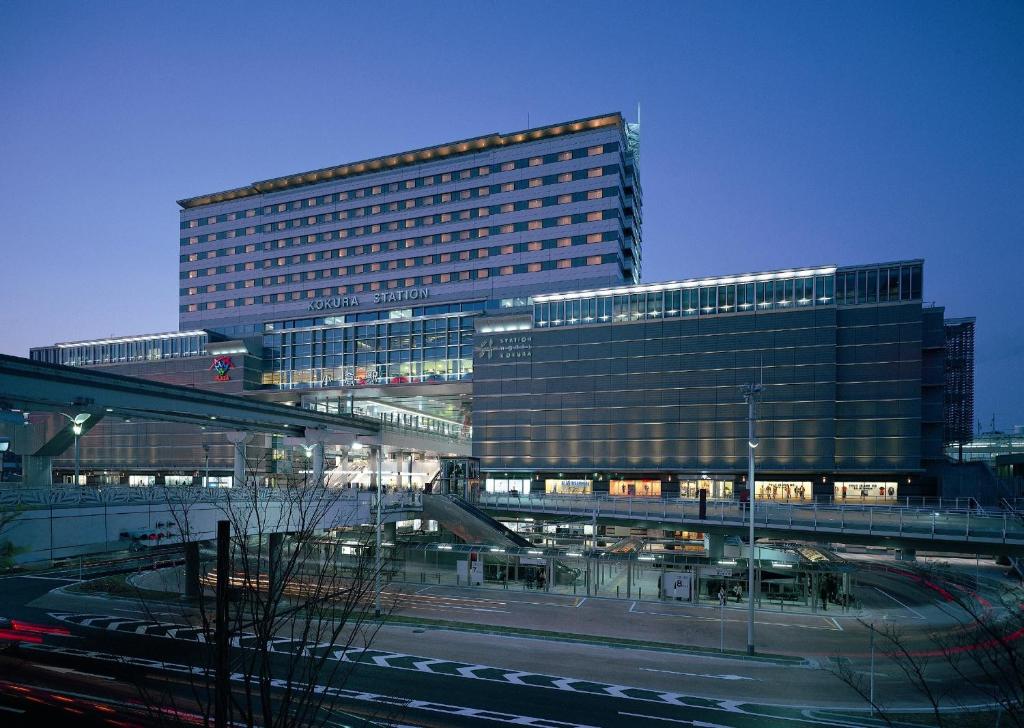 北九州JR Kyushu Station Hotel Kokura的前面有火车的高楼