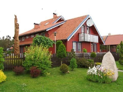 奈达维拉埃尔度假屋的红色的房子,有栅栏和鲜花庭院