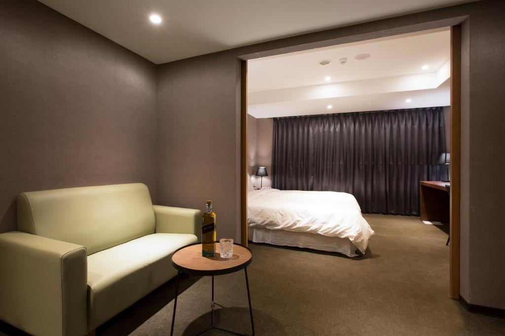 台北贵族商务饭店的酒店客房配有床、沙发和桌子。