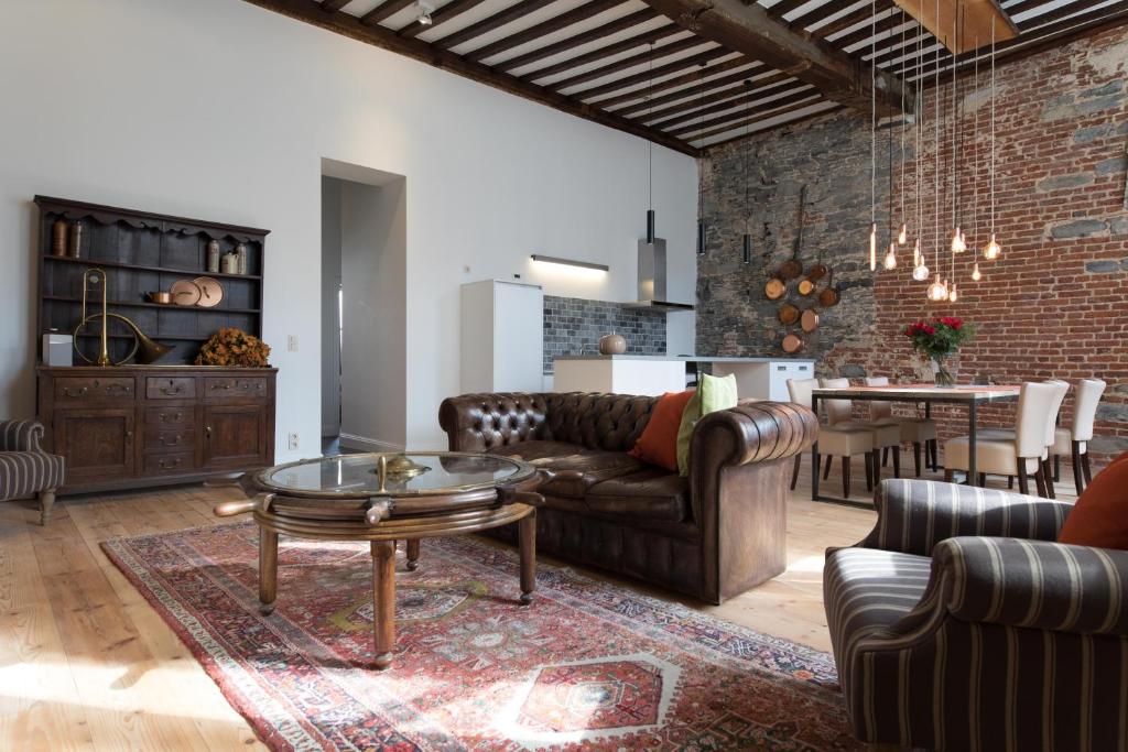 根特西班牙法院公寓的客厅配有皮革家具和砖墙
