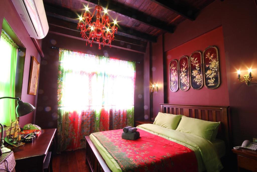 宋卡班奈娜旅馆的一间卧室配有一张带红毯和吊灯的床。